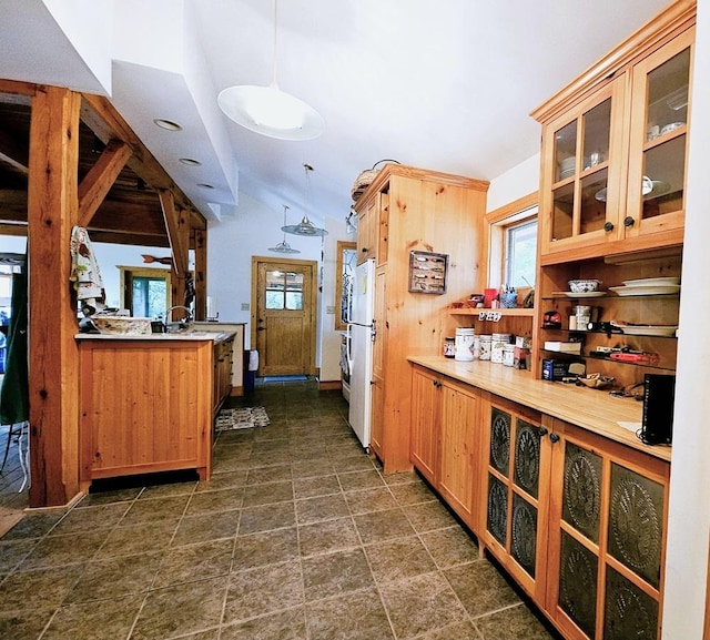 kitchen with glass insert cabinets, lofted ceiling, a healthy amount of sunlight, and decorative light fixtures