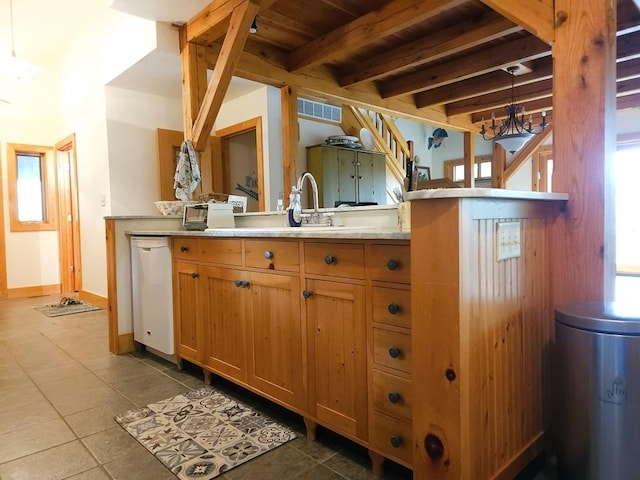 kitchen with white dishwasher, tile patterned flooring, baseboards, light countertops, and beam ceiling