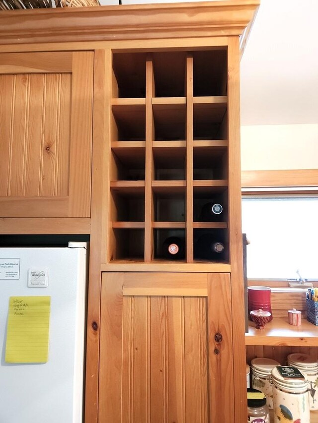 interior details with light brown cabinetry and freestanding refrigerator