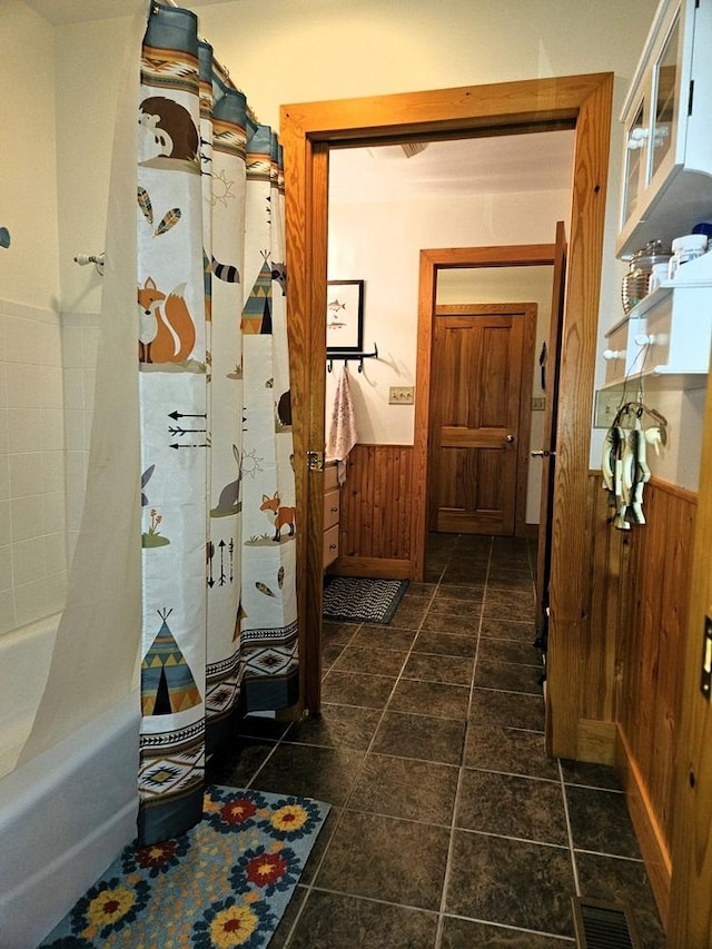 interior space featuring wainscoting, visible vents, and wooden walls