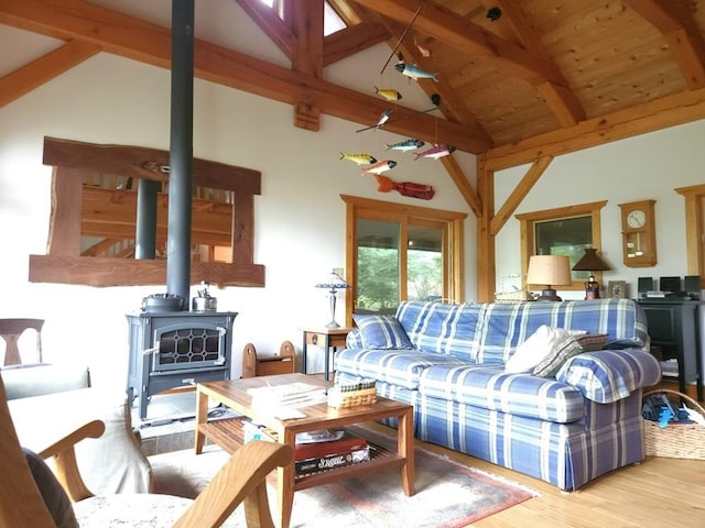 living area with a wood stove, high vaulted ceiling, light wood-type flooring, wooden ceiling, and beamed ceiling