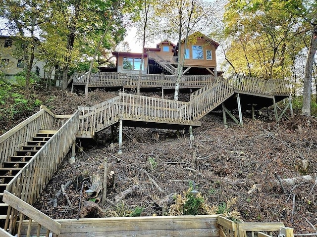 back of house featuring stairway and a wooden deck