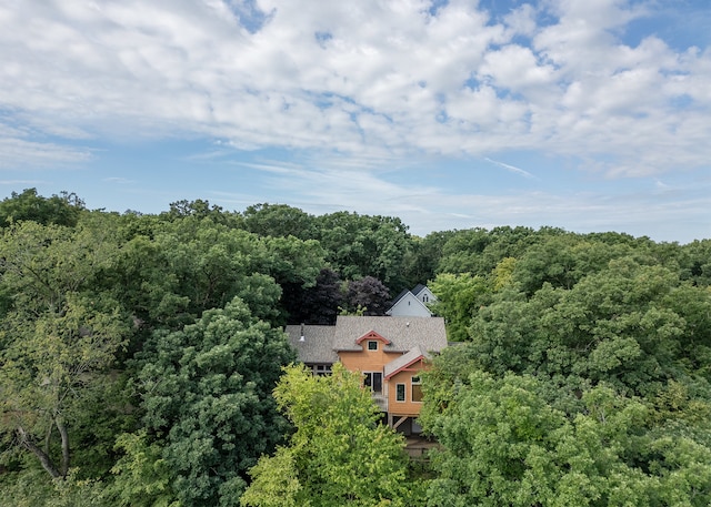 drone / aerial view featuring a wooded view