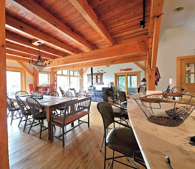 dining room featuring wooden ceiling, light wood-style floors, a notable chandelier, and beamed ceiling