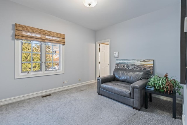 living area with carpet flooring, visible vents, and baseboards