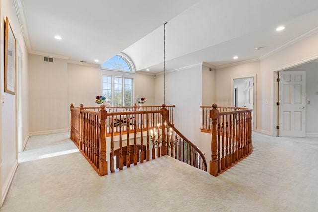 hall with carpet flooring, an upstairs landing, and visible vents