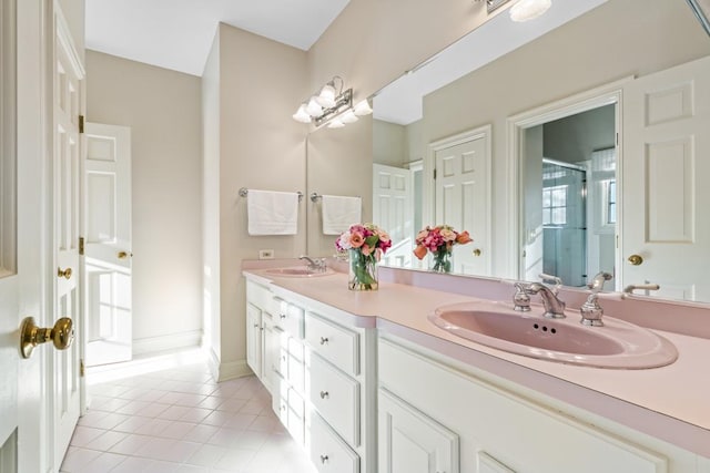 full bathroom featuring a shower stall, double vanity, a sink, and tile patterned floors