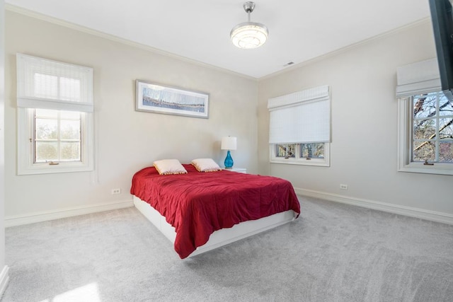 carpeted bedroom featuring ornamental molding, multiple windows, and baseboards