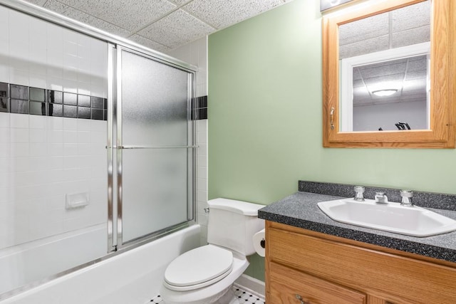 bathroom with toilet, enclosed tub / shower combo, a paneled ceiling, and vanity