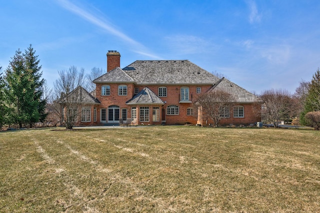 exterior space featuring a chimney, a lawn, and brick siding