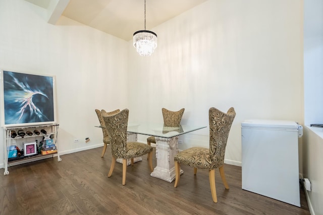 dining room featuring a notable chandelier, baseboards, and wood finished floors