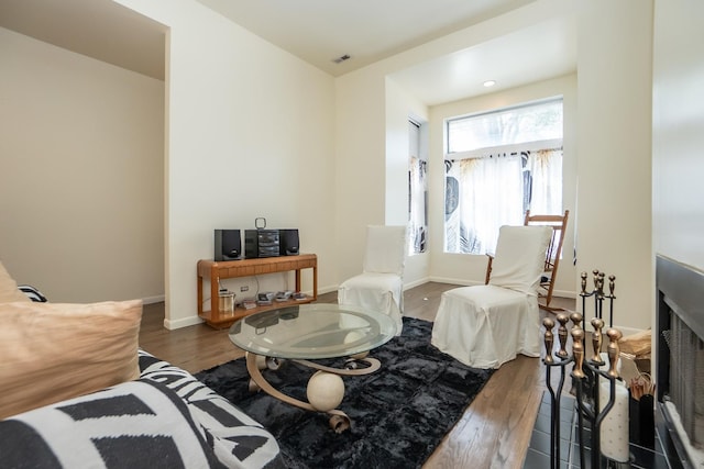 living area with baseboards, visible vents, and wood finished floors