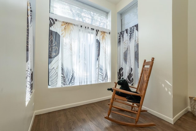 living area with baseboards and wood finished floors