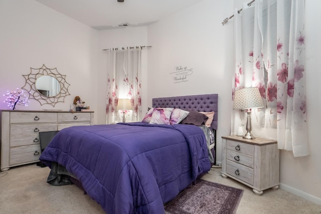 bedroom featuring baseboards, visible vents, and light colored carpet