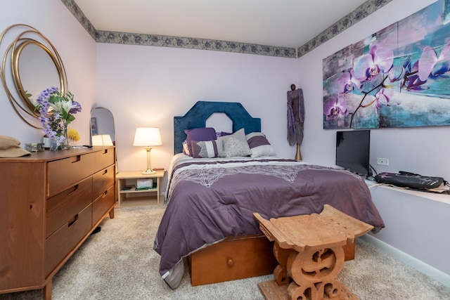 bedroom featuring light carpet and baseboards