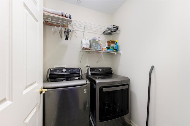 laundry room featuring laundry area, washing machine and dryer, and baseboards