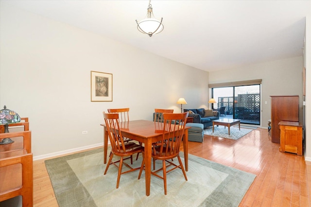 dining area with baseboards and light wood finished floors