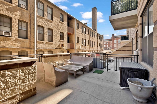 view of patio with an outdoor living space and a balcony