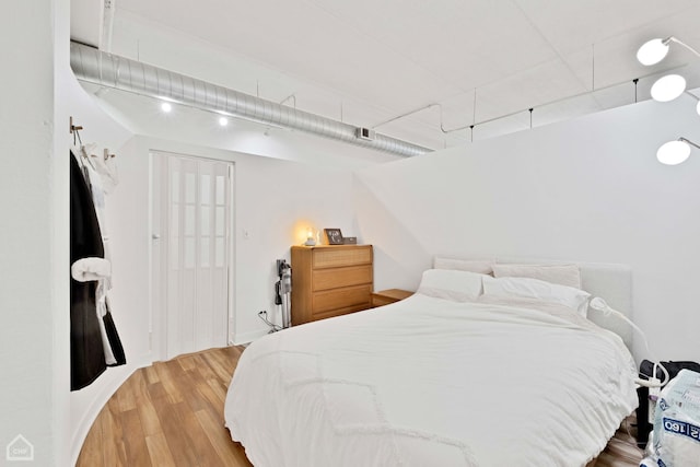 bedroom featuring visible vents and wood finished floors