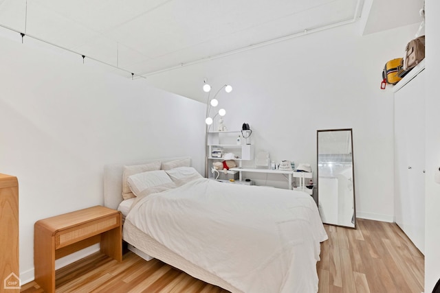 bedroom featuring light wood-type flooring and baseboards