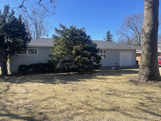 exterior space with a front lawn, a garage, and roof with shingles