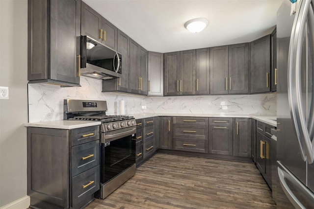 kitchen featuring backsplash, appliances with stainless steel finishes, dark wood finished floors, and light countertops