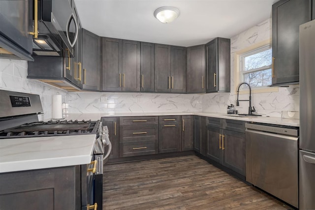 kitchen featuring dark wood-type flooring, a sink, tasteful backsplash, stainless steel appliances, and dark brown cabinets