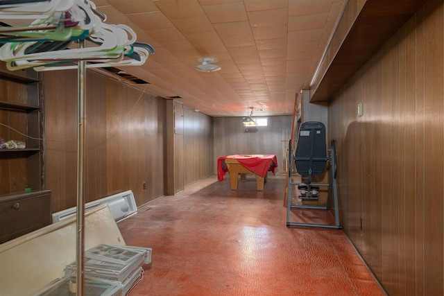 below grade area with wooden walls, a baseboard heating unit, and billiards