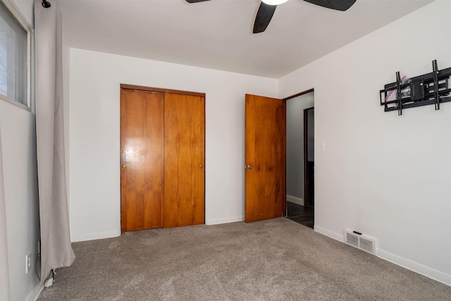 unfurnished bedroom with a closet, visible vents, carpet flooring, and baseboards