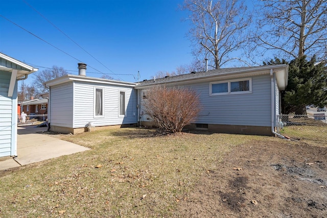 rear view of house featuring a yard, fence, and crawl space