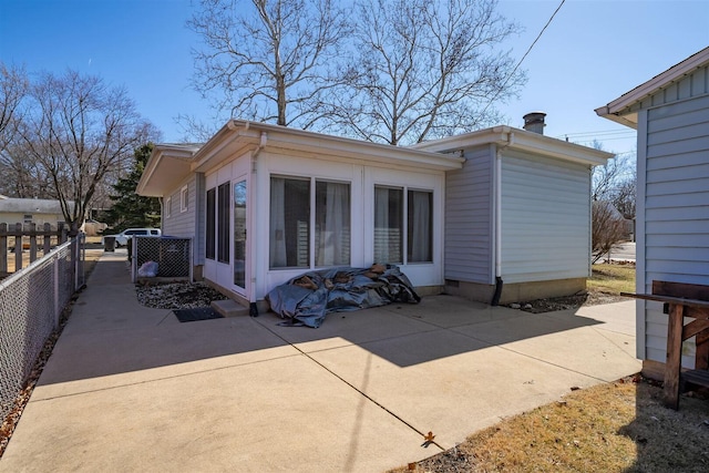 rear view of house featuring a patio and fence