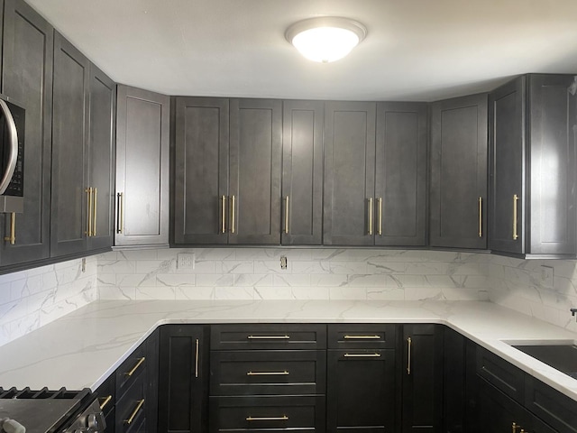 kitchen featuring a sink, light stone countertops, and backsplash