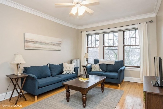 living area with plenty of natural light, light wood-style flooring, and crown molding