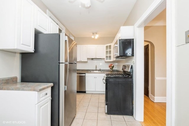 kitchen featuring tasteful backsplash, appliances with stainless steel finishes, a sink, and white cabinets