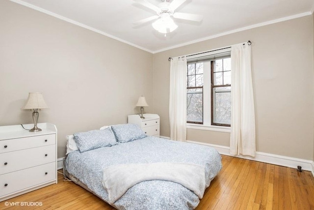 bedroom featuring light wood-style floors, crown molding, baseboards, and ceiling fan