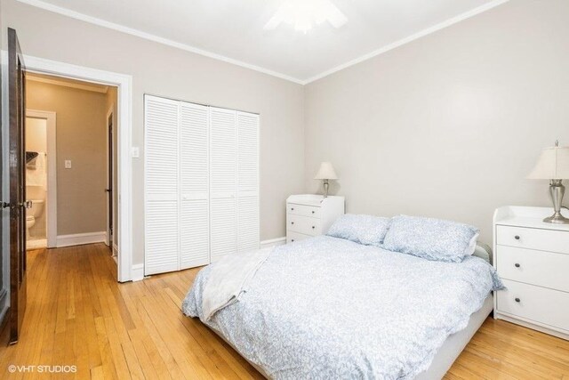 bedroom with crown molding, a closet, light wood-style floors, a ceiling fan, and baseboards