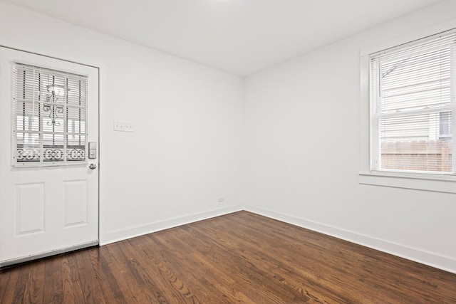 unfurnished room featuring dark wood-type flooring and baseboards