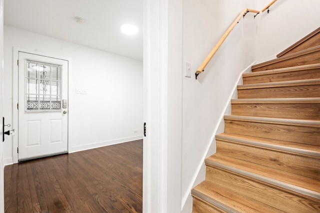 staircase with baseboards and wood finished floors