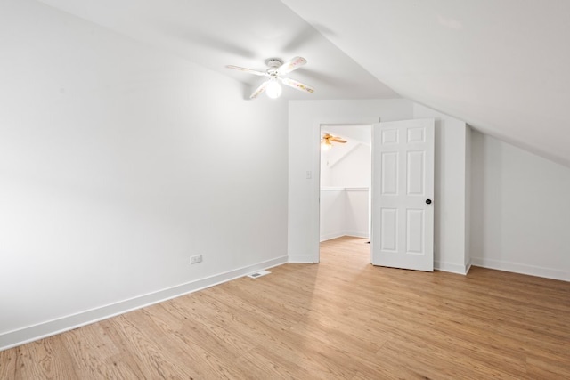 bonus room with baseboards, lofted ceiling, and light wood-style floors