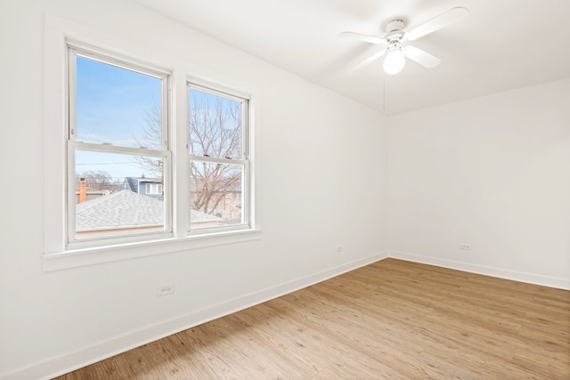 empty room featuring baseboards, ceiling fan, and light wood finished floors