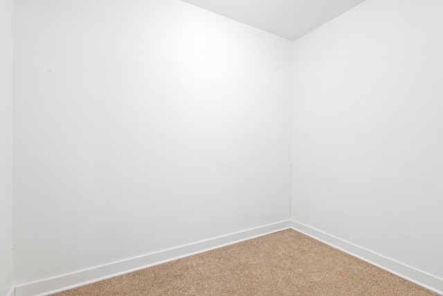 empty room with light colored carpet and baseboards