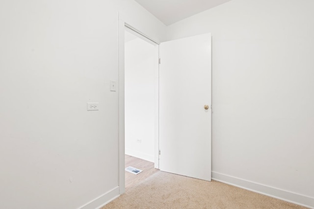 unfurnished room featuring light carpet, baseboards, and visible vents