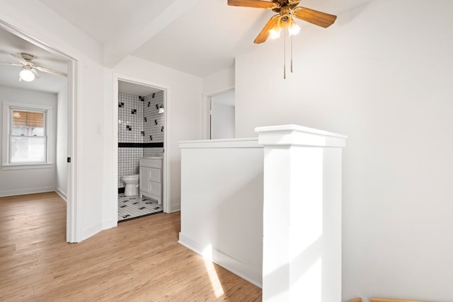 corridor featuring light wood-style flooring and baseboards