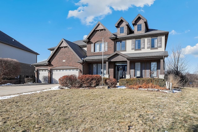 view of front of house with a garage, brick siding, driveway, and a front lawn