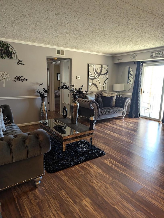 living area with visible vents, crown molding, a textured ceiling, and wood finished floors