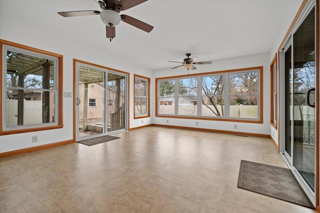 unfurnished sunroom with ceiling fan