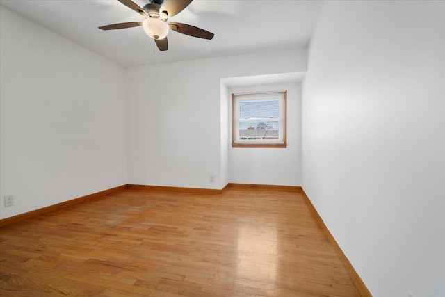 spare room featuring light wood-style floors, ceiling fan, and baseboards