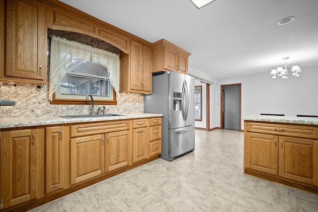 kitchen with light floors, plenty of natural light, a sink, and stainless steel fridge with ice dispenser