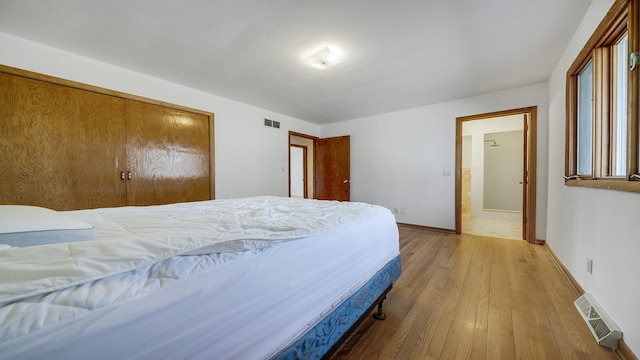 bedroom featuring baseboards, visible vents, and hardwood / wood-style floors