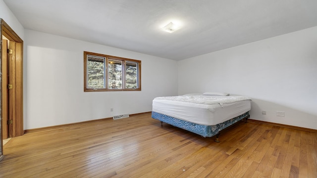 bedroom with light wood-style floors, baseboards, and visible vents